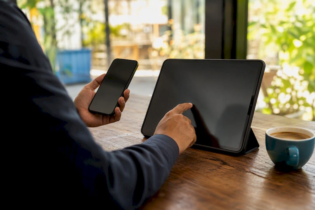 Hands interacting with smartphone and tablet